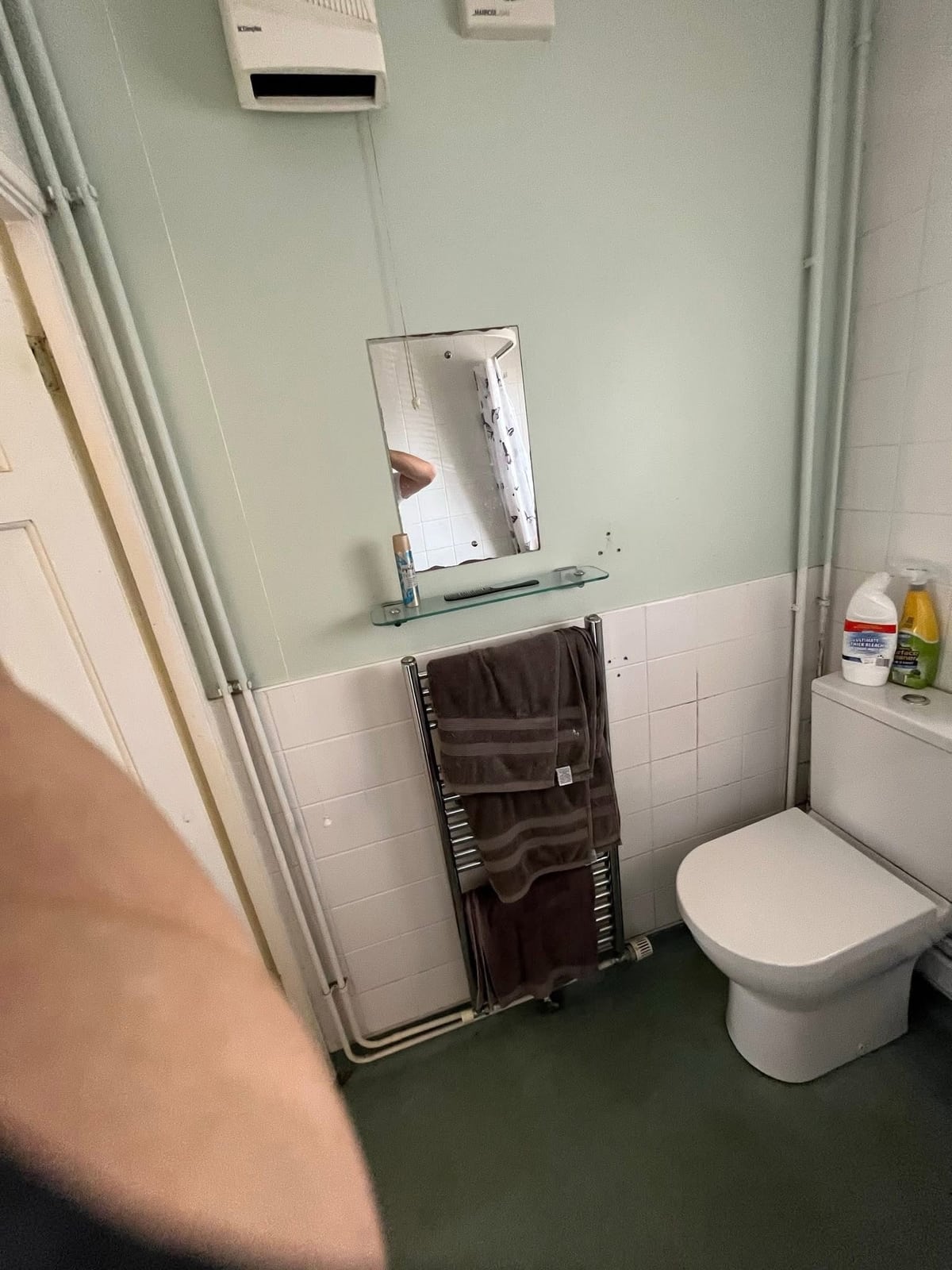 Original bathroom showing toilet and tired wall finishes